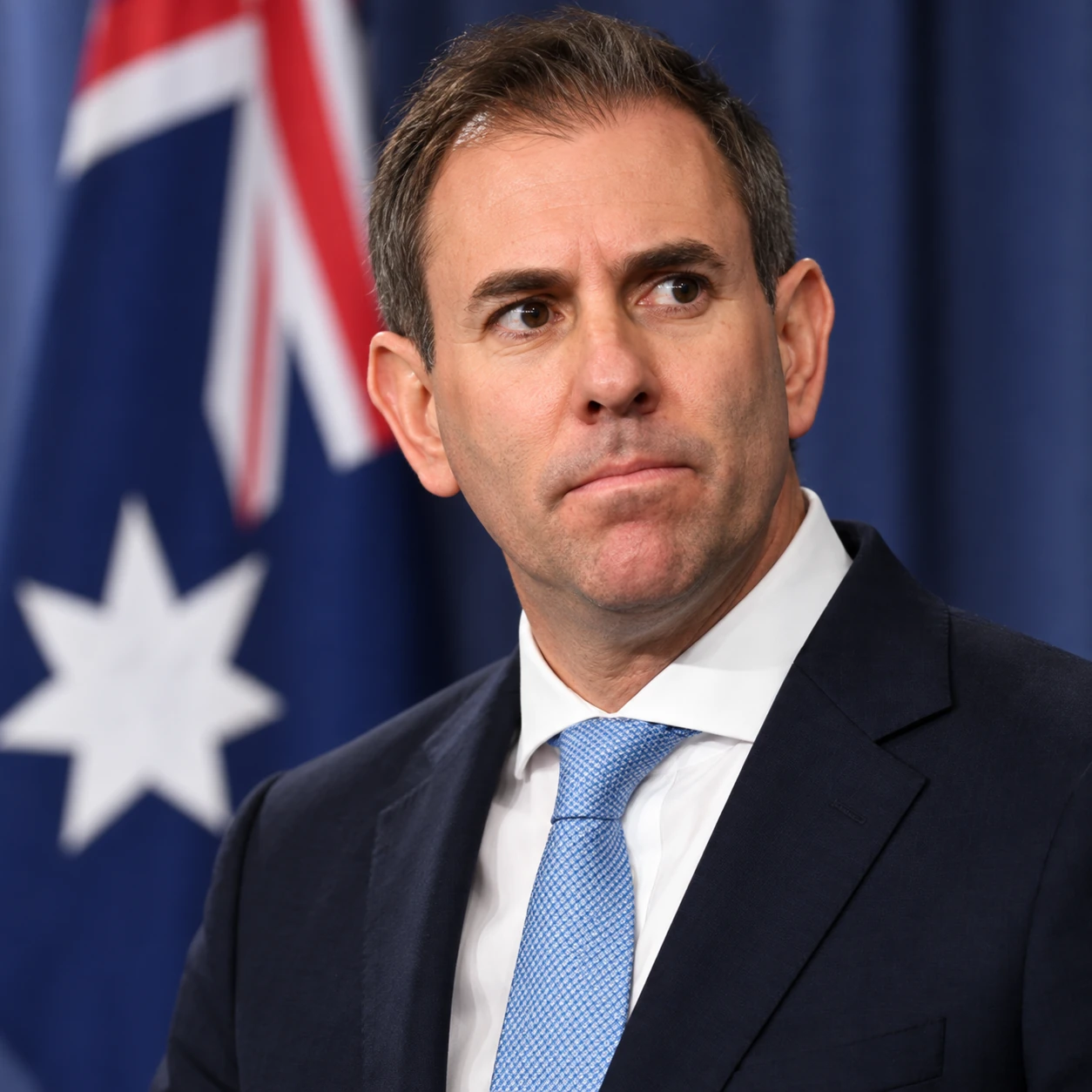 Treasurer Jim Chalmers in front of an Australian flag