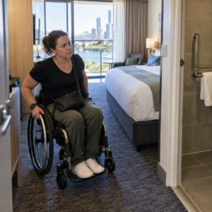 Wheelchair user inspecting an accessible hotel room in Queensland.