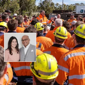 Whyalla Steelworks workers in orange high visibility clothing gathered for a workplace meeting